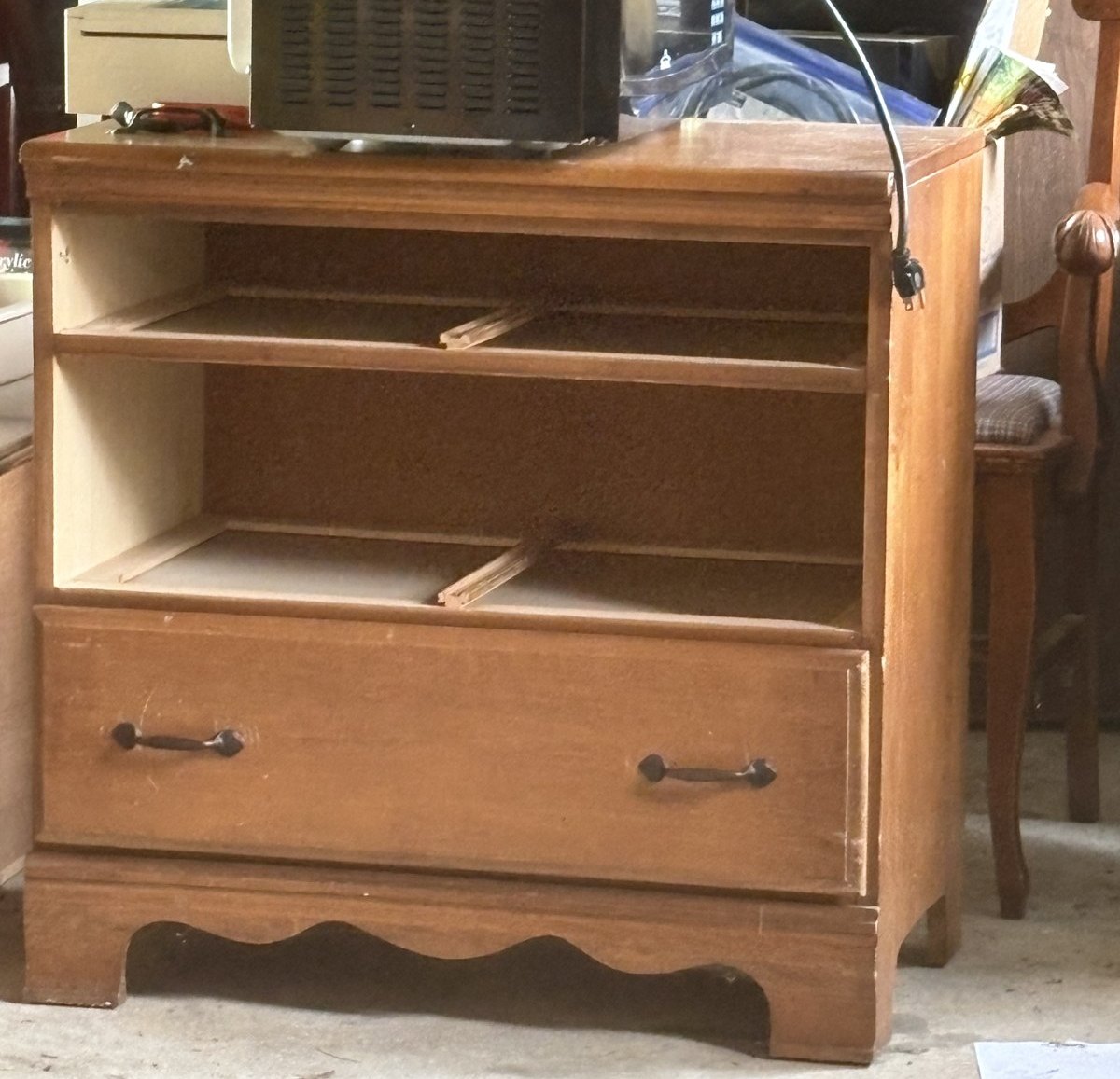 Before: worn honey-toned dresser in a garage with two empty drawer openings