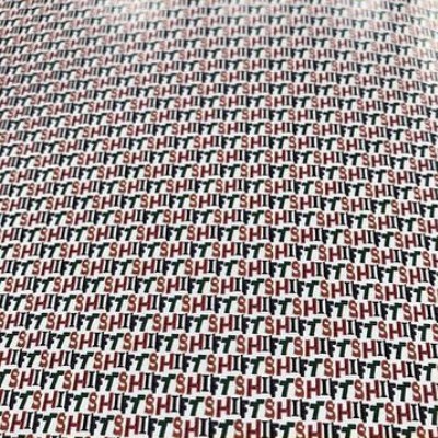 Close-up of the repeating SHIFT lettering pattern in red, black and green