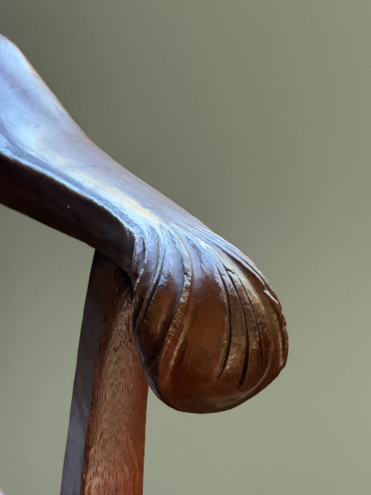 Close-up of the armchair's carved, scrolled arm end