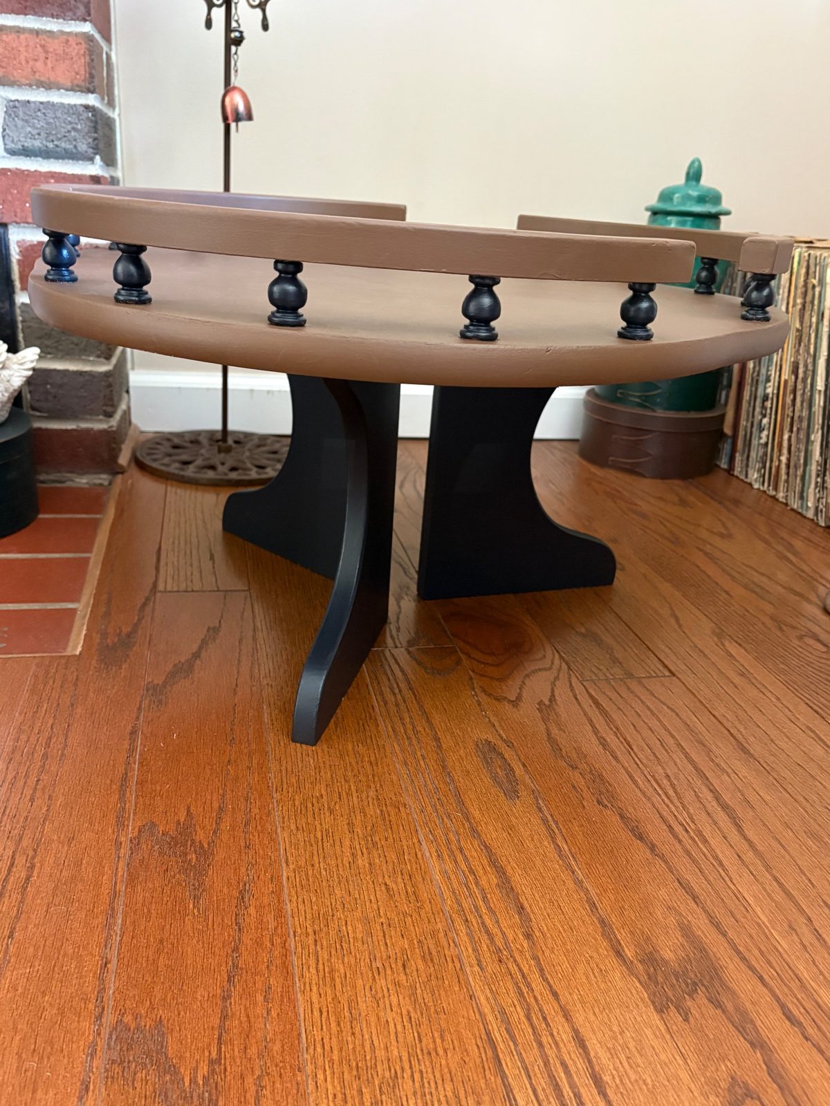 Side view of the upper tier, showing the dark curved base pieces under the brown top and rail